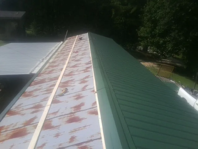 Old rusted panels beside newly installed green metal roofing — Wind Damage Roof Repair by Roofing Brothers in West Hills